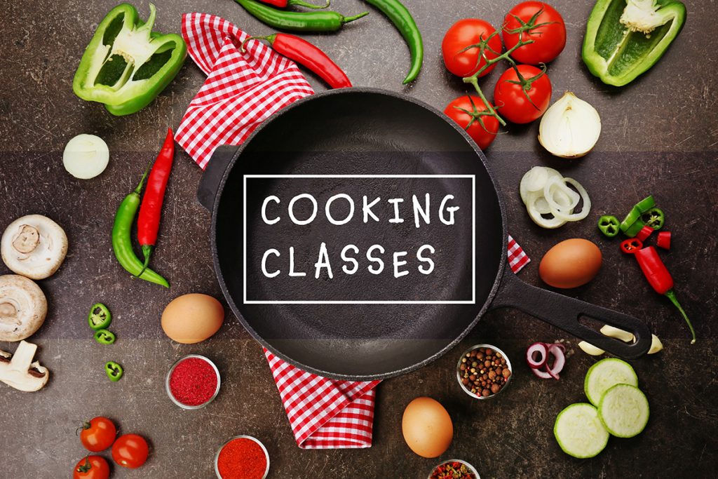 Cooking classes concept. Frying pan with fresh ingredients on gray background